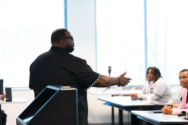 Stringer Harris wearing a black shirt and speaking to participants in a classroom