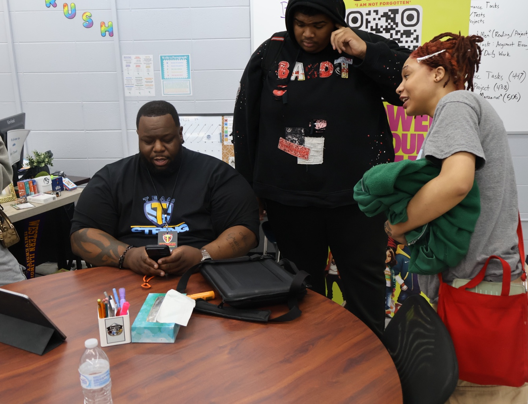 A TeamString mentor working with young people at a classroom table